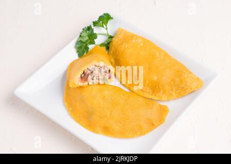 Angolo alto di delizioso polpaccio colombiano ripieno di carne macinata su fondo leggero ripieno di carne macinata e maiale con cipollina tritata e fr Foto Stock