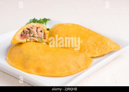 Angolo alto di delizioso polpaccio colombiano ripieno di carne macinata su fondo leggero ripieno di carne macinata e maiale con cipollina tritata e fr Foto Stock