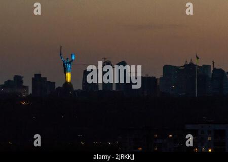 KIEV, UCRAINA - 24 AGOSTO 2022 - le travi blu e gialle (colori nazionali dell'Ucraina) illuminano il Monumento della Patria sull'indipendenza del 31st Foto Stock