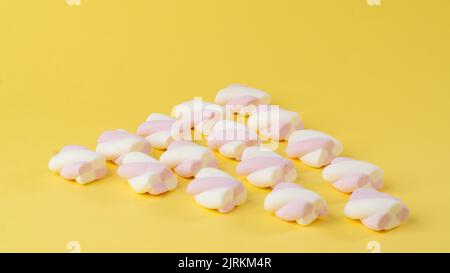 Marshmallow su sfondo giallo sotto forma di triangolo Foto Stock