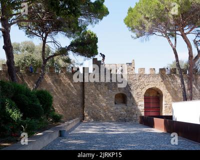 Terreni di St. Georges a Lisbona, Portogallo, in una giornata estiva, mentre un turista sale su una serie di gradini Foto Stock