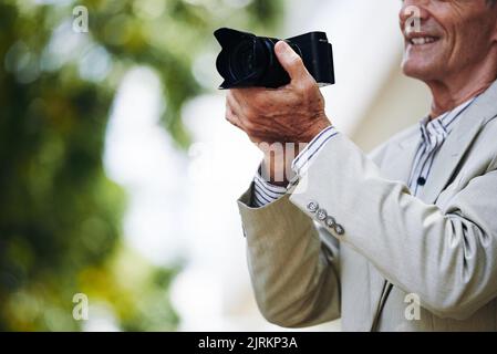 Immagine ritagliata di un fotografo professionista anziano che lavora all'aperto Foto Stock