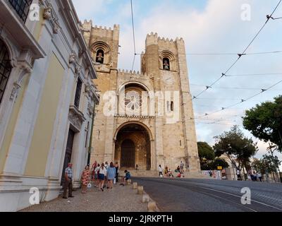 Cattedrale di Santa Maria maggiore, nota anche come Cattedrale di Lisbona, nota anche come sé de Lisboa. I turisti camminano in strada con le sue linee del tram. Foto Stock