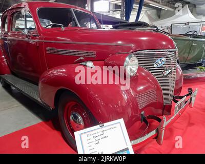 Old Red 1939 Chevrolet Chevy Master Coupe di GM su un tappeto rosso. Sala espositiva. Naso. Cromi. Griglia. Spettacolo di auto classica. Foto Stock