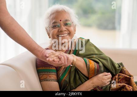 Ritratto di donna anziana felice che tiene la mano del suo coniuge Foto Stock