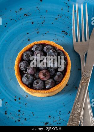 Torta al mirtillo appena sfornata su una piastra di porcellana blu Foto Stock