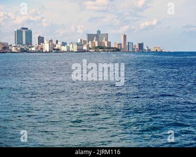 Una vista dello skyline dell'Avana sull'acqua blu in una calda giornata di sole, Cuba. Riflessione della luce solare sulla superficie dell'acqua, nuvole sullo sfondo Foto Stock