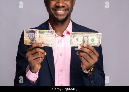 uomo nero con naira e banconote in dollari Foto Stock