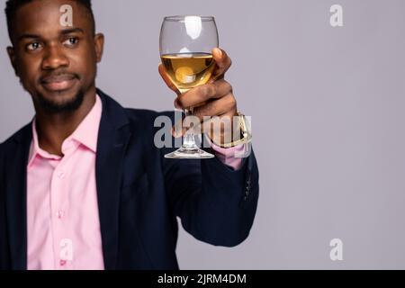 uomo nero che alza un bicchiere di vino da vicino Foto Stock
