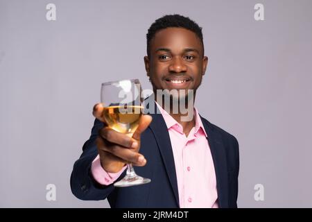 giovane uomo d'affari nero che alza un bicchiere Foto Stock