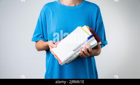 Studentessa con libri e quaderni nelle sue mani - formazione Foto Stock