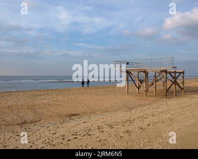 Una coppia che cammina su una spiaggia di sabbia dorata Foto Stock