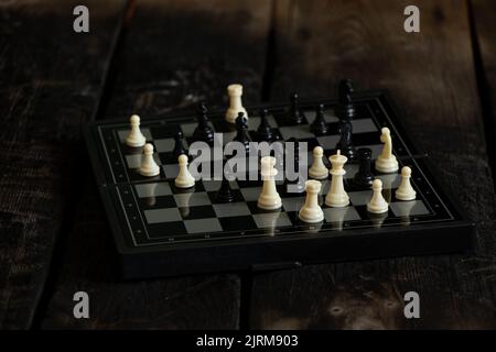 scacchi stand su un vecchio tavolo di legno nero, gioco di scacchi, pezzi di scacchi Foto Stock