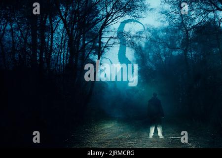 Un concetto orrore di un uomo che guarda un mostro di cthulhu con tentacoli. Uscire dalla nebbia su una foresta di neve di notte. Foto Stock