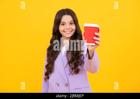 Ragazza sorridente felice della scuola che tiene la tazza del caffè, imparante ed educazione. Pausa caffè e pausa scolastica. Ritorno a scuola. Teenager studente di plastica Foto Stock