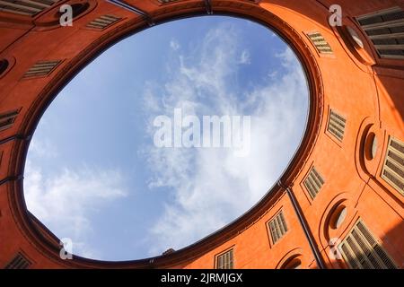 Cortile di ovale arancione teatro comunale a Ferrara, Italia con vista sul cielo per un contesto di gestione immobiliare commerciale Foto Stock