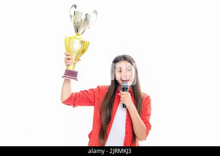 Ragazza adolescente con conversazione microfono della tazza di vincita. Teen in possesso di un trofeo. Il bambino vincitore ha vinto il concorso, celebrando il successo e la vittoria. Foto Stock