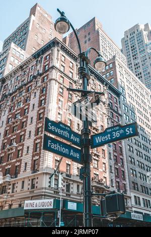 La vista verticale ad angolo basso degli edifici di Manhattan e le indicazioni stradali a New York City Foto Stock