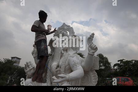 Nuova Delhi, India. 25th ago, 2022. Un artista lavora su un idolo della divinità indù a testa di elefante Ganesha davanti al festival di Ganesh Chaturthi a Nuova Delhi. Ganesh Chaturthi è un festival indù di dieci giorni celebrato per onorare il compleanno del Dio Ganesha, a capo di un elefante. Credit: SOPA Images Limited/Alamy Live News Foto Stock