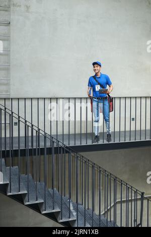 Allegro giovane corriere vietnamita con frigorifero consegna cibo Foto Stock