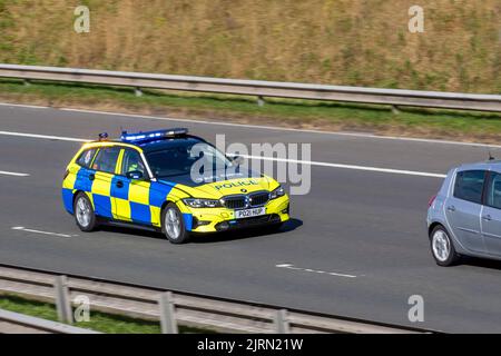 TAC Ops, divisione Lancashire Tactical Operations. Polizia del Regno Unito traffico veicolare, trasporti, moderno, BMW berlina auto lampeggio luci blu, fermata del traffico sulla 3 corsie M6 autostrada. Foto Stock