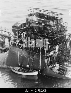 Una foto d'epoca del 1942 che mostra una nave mercantile che affonda dopo essere stata siledata da un sottomarino tedesco mentre attraversava l'oceano Atlantico durante la seconda guerra mondiale. L'equipaggio ha abbassato una barca di vita e sta cercando di lasciare la nave Foto Stock