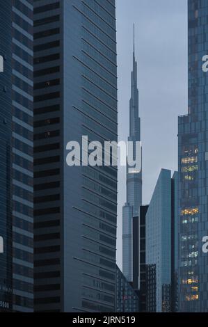 Dubai, Emirati Arabi Uniti: Primo piano verticale del Burj Khalifa, il grattacielo più alto del mondo, incorniciato da edifici moderni. Foto Stock