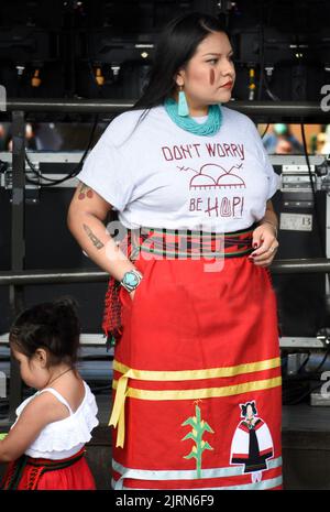 Una donna dei nativi americani (Hopi) è in piedi dietro il palco durante il Concorso di abbigliamento dei nativi americani al mercato indiano di Santa Fe a Santa Fe, New Mexico. Foto Stock