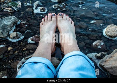 Pedicure patriottica tra la St. Croix River Rocks e acque poco profonde a Taylors Falls, Minnesota USA. Foto Stock