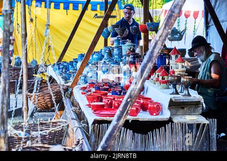 Gifhorn, Germania, 12 agosto 2022: Vasellame in ceramica rossa e blu con tazze, tazze e piatti in una bancarella su un mercato medievale Foto Stock