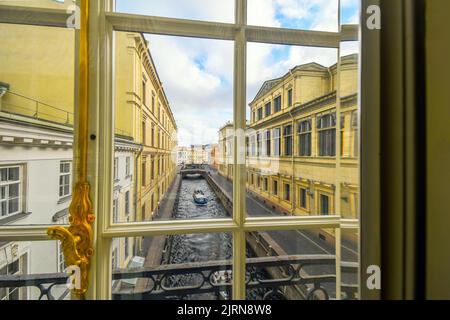 Un tour in barca scivola giù il Zimnyaya Kanavka Inverno Canal e il fiume Neva a San Pietroburgo Russia, vista da una finestra della galleria all'interno dell'Hermitage Foto Stock