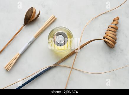 Design Zen, olio di incenso e bastoni di incenso con decorazione in legno profumato su uno sfondo di marmo grigio chiaro. Design e concetto di stile di vita e spa. Foto Stock