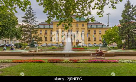 Szeged, Ungheria - 30 luglio 2022: Municipio neo barocco edificio storico punto di riferimento Vista dal parco cittadino con fontana. Foto Stock