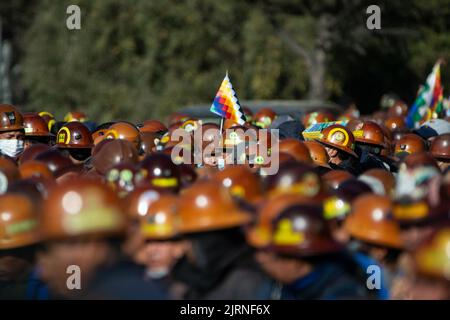 La Paz, Bolivia. 25th ago, 2022. I sostenitori del governo del presidente Arce partecipano a un raduno a sostegno del governo, che porta bandiere e che indossa caschi da miniera. "Stiamo iniziando questo grande raduno per il paese e la democrazia", ha scritto il leader boliviano su Twitter. Arce aveva chiamato per il rally. Egli ha affermato che si intendeva inviare un segnale contro i 'golpe plottatori di destra'. Credit: Radoslaw Czajkowski/dpa/Alamy Live News Foto Stock