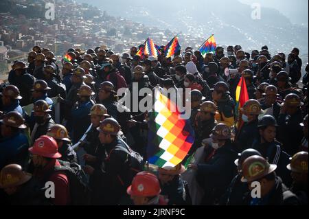 La Paz, Bolivia. 25th ago, 2022. I sostenitori del governo del presidente Arce marciano con bandiere e caschi minerari durante un raduno a sostegno del governo. "Stiamo iniziando questo grande raduno per il paese e la democrazia", ha scritto il leader boliviano su Twitter. Arce aveva chiamato per il rally. Egli ha affermato che si intendeva inviare un segnale contro i 'golpe plottatori di destra'. Credit: Radoslaw Czajkowski/dpa/Alamy Live News Foto Stock