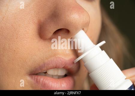 spray per un naso nel naso di una ragazza, gocce di naso, gri n e raffreddori, non può respirare, congestione nasale, medicina Foto Stock