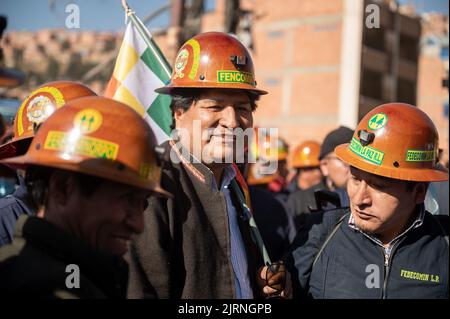 La Paz, Bolivia. 25th ago, 2022. Evo Morales (m.), ex presidente della Bolivia, indossa un casco con il nome dell'associazione mineraria Fencomin durante un raduno a sostegno del governo. "Stiamo iniziando questo grande raduno per il paese e la democrazia", ha scritto il leader boliviano Arce su Twitter. Arce aveva chiamato per il rally. Egli ha affermato che si intendeva inviare un segnale contro i 'golpe plottatori di destra'. Credit: Radoslaw Czajkowski/dpa/Alamy Live News Foto Stock