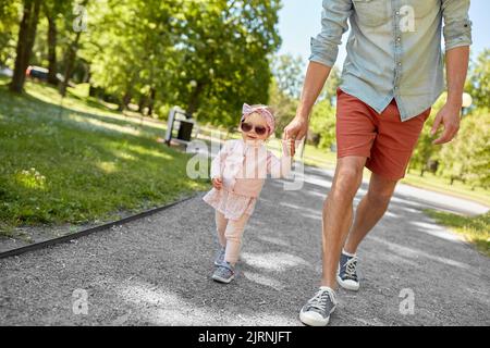 padre con bambina che cammina nel parco estivo Foto Stock