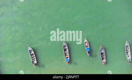 Molte barche da pesca vicino al mare nelle isole tropicali. Molo degli abitanti del villaggio sull'isola meridionale della Thailandia. Vista dall'alto dai fuchi. Foto Stock