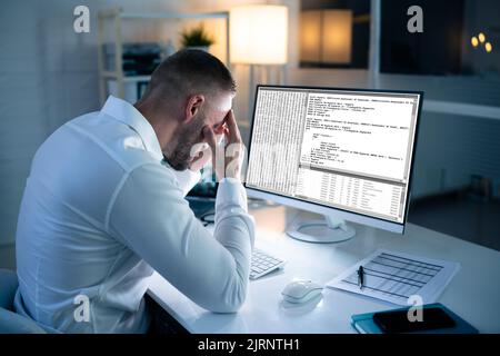 Infelice Sad Developer Programmer Man in stress Coding Software su computer Foto Stock