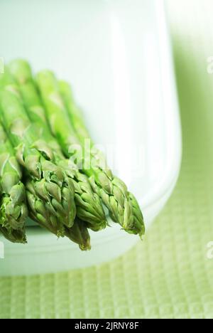 Un mazzo di asparagi crudi in una ciotola, Asparagus officinalis Foto Stock