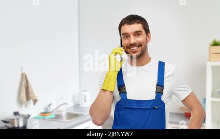 lavoratore maschio o pulitore che chiama sul telefono in cucina Foto Stock