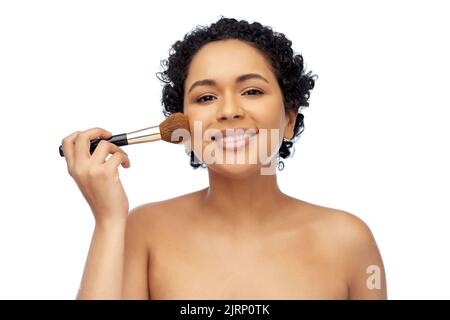donna con make up pennello applicazione di arrossamento al viso Foto Stock