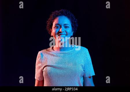 donna africana su luci al neon su sfondo nero Foto Stock
