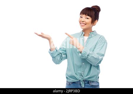 Felice donna asiatica holding qualcosa a portata di mano Foto Stock