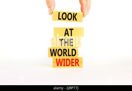 Guarda il simbolo del mondo. Le parole di concetto guardano il mondo più in generale su blocchi di legno su uno sfondo bianco bello. Mano uomo d'affari. Business e. Foto Stock