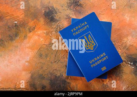 Due passaporti biometrici ucraini blu su sfondo nero e arancione. Minimalismo. Indipendenza, democrazia, identificazione, viaggi, turismo, busines Foto Stock