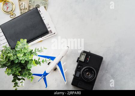 Composizione creativa. Pianificare un viaggio, una vacanza, una vacanza. Aereo, passaporto, denaro, macchina fotografica su sfondo bianco. Non ci sono persone nella foto. Foto Stock