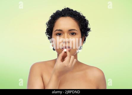 ritratto di donna afroamericana che prende la pillola Foto Stock