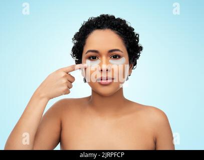 donna afroamericana con cerotti per occhio di idrogel Foto Stock